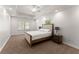 Bright bedroom with neutral carpet, a bed with a light wood frame, and two side tables with lamps at 1900 Chattahoochee Run Dr, Suwanee, GA 30024