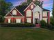 Stately brick home with manicured landscaping, a striking entrance, and elegant architectural details at 1900 Chattahoochee Run Dr, Suwanee, GA 30024
