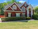 Charming brick home with manicured landscaping, striking entrance, and a lush green lawn at 1900 Chattahoochee Run Dr, Suwanee, GA 30024