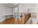 Hallway with hardwood floors, built-in shelves, wood railing, and staircase at 1900 Chattahoochee Run Dr, Suwanee, GA 30024