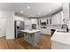 Beautiful kitchen features a gray kitchen island, stainless steel appliances, white cabinets, and hardwood flooring at 1900 Chattahoochee Run Dr, Suwanee, GA 30024