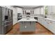 Open kitchen with stainless steel appliances, a gray kitchen island, and gorgeous hardwood flooring at 1900 Chattahoochee Run Dr, Suwanee, GA 30024
