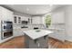 Bright kitchen featuring an island with stone countertop, stainless steel appliances, and hardwood flooring at 1900 Chattahoochee Run Dr, Suwanee, GA 30024
