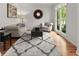 Cozy living room with hardwood floors, comfortable seating, and natural light from a large window at 1900 Chattahoochee Run Dr, Suwanee, GA 30024