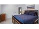 Bedroom with neutral carpet, a wood dresser and a bed featuring a dark wood frame and blue patterned bedspread at 4794 Dalhousie Ne Pl, Marietta, GA 30068