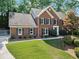 Traditional brick home on a well-maintained lawn, featuring a mature shade tree and dark blue shutters at 4794 Dalhousie Ne Pl, Marietta, GA 30068