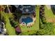 Beautiful aerial view showcasing the pool, spa, deck, and verdant landscaping of the home's outdoor space at 7390 Canter Run, Cumming, GA 30040