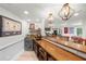 A modern basement bar with wood counter, beverage cooler, storage shelves, and recessed lights for a casual atmosphere at 7390 Canter Run, Cumming, GA 30040