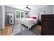 Bedroom features a full bed, wood floors, a large mirror, and bright pink accents at 7390 Canter Run, Cumming, GA 30040