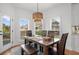 Bright dining area features a wooden table, seating for six, and a stylish woven light fixture at 7390 Canter Run, Cumming, GA 30040
