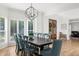 Spacious dining room featuring wooden floors, large windows with shutters, and a modern chandelier at 7390 Canter Run, Cumming, GA 30040