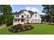 Stunning white painted brick two-story home with manicured lawn and beautiful landscape design at 7390 Canter Run, Cumming, GA 30040