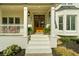 Close up of the front porch with double wooden doors, ferns, and rocking chairs at 7390 Canter Run, Cumming, GA 30040