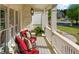 Spacious front porch with white columns and railing and patio furniture with decorative pillows at 7390 Canter Run, Cumming, GA 30040