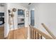 Hallway with hardwood floors leading to a laundry room, decorated with a charming ladder and hats at 7390 Canter Run, Cumming, GA 30040