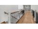 Bright hallway with hardwood floors, black metal railing, and decorative wallpaper at 7390 Canter Run, Cumming, GA 30040