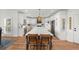 Bright kitchen showcasing white cabinets, a long island with seating, and views into the dining area at 7390 Canter Run, Cumming, GA 30040