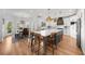 Modern kitchen featuring white cabinets, a large island, and stainless steel appliances next to the dining area at 7390 Canter Run, Cumming, GA 30040