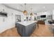 Open kitchen with a large island, white cabinets, stainless steel appliances, and a view into the living area at 7390 Canter Run, Cumming, GA 30040