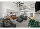 Expansive living room featuring a fireplace, staircase, and open view into a modern kitchen with white cabinetry at 7390 Canter Run, Cumming, GA 30040