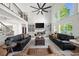 Open-concept living room with a stone fireplace, built-in cabinets, and large windows showing a treed view at 7390 Canter Run, Cumming, GA 30040