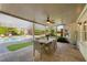 A covered patio with seating, ceiling fan, and view of the backyard pool area, perfect for dining at 7390 Canter Run, Cumming, GA 30040