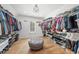 Spacious walk-in closet with custom shelving, an abundance of storage space and a comfortable center ottoman at 7390 Canter Run, Cumming, GA 30040