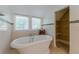Bright bathroom features a clawfoot tub next to two windows and a walk in closet at 1195 Cameron Ne Ct, Atlanta, GA 30306
