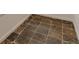 Close-up of a brown ceramic tile floor with gray grout and a white baseboard at 1195 Cameron Ne Ct, Atlanta, GA 30306