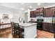 Modern kitchen with a granite island, stainless steel appliances, and stylish dark wood cabinetry at 155 Point View Dr, Canton, GA 30114