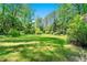 Lush backyard with plenty of green space surrounded by mature trees and flowering bushes at 3157 Brooks Dr, Snellville, GA 30078
