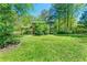 Expansive backyard view with lush green grass, mature trees, and natural sunlight at 3157 Brooks Dr, Snellville, GA 30078