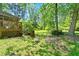 Large backyard with mature trees, grassy area, and a glimpse of the home's deck at 3157 Brooks Dr, Snellville, GA 30078