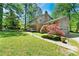 Spacious home with mature trees, a well-manicured lawn, and a two-car garage at 3157 Brooks Dr, Snellville, GA 30078