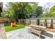 Fenced backyard featuring artificial turf, a colorful play area, and stone patio with dining set at 342 5Th Ne St, Atlanta, GA 30308