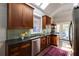 Galley kitchen featuring wooden cabinets, stainless steel appliances, granite counters, and adjacent door to deck at 342 5Th Ne St, Atlanta, GA 30308