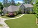 Beautiful brick home showcasing manicured lawn, lush landscaping, and curved driveway at 3590 Fricks Rd, Marietta, GA 30062