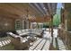 Beautiful pergola area with a stone fireplace, ceiling fan, string lights, and cushioned wicker seating at 3590 Fricks Rd, Marietta, GA 30062