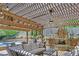 Cozy pergola area with plenty of seating space and includes a stone fireplace, grill, and ceiling fan at 3590 Fricks Rd, Marietta, GA 30062
