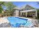 Large in-ground pool featuring stone patio surround, wood pergola dining area, covered patio, and brick home at 3590 Fricks Rd, Marietta, GA 30062
