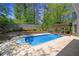 In-ground pool with a wood pergola covered outdoor dining area, with landscaping and a privacy fence at 3590 Fricks Rd, Marietta, GA 30062