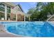 Large in-ground pool with a covered patio and brick house in background, with plenty of sunlight at 3590 Fricks Rd, Marietta, GA 30062
