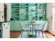 Bright breakfast nook with custom mint-colored shelving and a round glass table for intimate dining at 1440 Hillpine Ln, Atlanta, GA 30306
