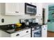 Modern kitchen with stainless steel appliances, dark granite countertops, and custom white cabinetry at 1440 Hillpine Ln, Atlanta, GA 30306