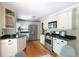 Well-lit kitchen featuring white cabinets, stainless steel appliances, and hardwood floors at 1440 Hillpine Ln, Atlanta, GA 30306