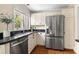 Bright kitchen with stainless steel appliances, white cabinets, and a view of the backyard from the sink window at 1440 Hillpine Ln, Atlanta, GA 30306