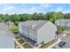 Aerial view of townhomes with manicured lawns, sidewalks and parking, surrounded by mature trees at 2110 Prichard Park Dr, Kennesaw, GA 30144