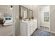 Bright bathroom featuring a double vanity with framed mirrors and an open view into the well-lit main bedroom at 2110 Prichard Park Dr, Kennesaw, GA 30144