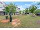 A dog park with grass and waste stations in a community with trees and multiple townhomes at 2110 Prichard Park Dr, Kennesaw, GA 30144