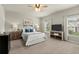 Bright main bedroom with neutral walls, ceiling fan, plush carpet, and windows providing natural light at 2110 Prichard Park Dr, Kennesaw, GA 30144